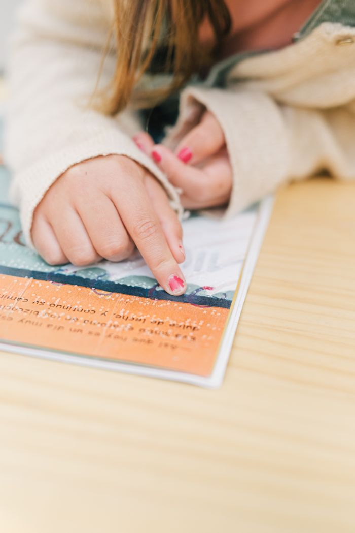 Home2 Childs hand reading braille text on a book, emphasizing tactile learning