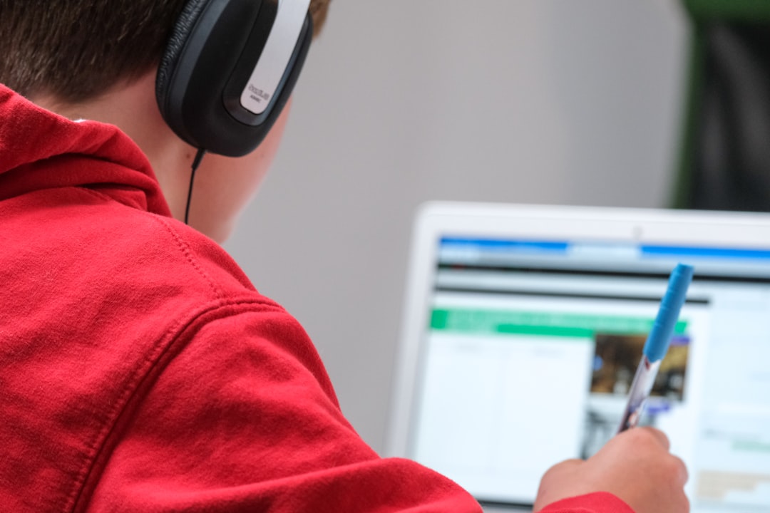 Home2 Home schooling during lockdown, boy working on school work with laptop and headphones during coronavirus covid 19 lock down. Remote learning through home schooling due to school closures has become commonplace in the UK in 2021.